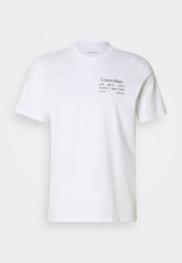 Tricou din bumbac alb, cu mâneci scurte, guler tip crew și text tipărit: "Calvin Klein 205 WEST 39TH STREET NEW YORK CITY 10018."