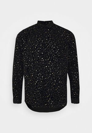 Sort skjorte med lange ærmer og knapper foran med leopardmønster og små reflekterende prikker spredt over stoffet.