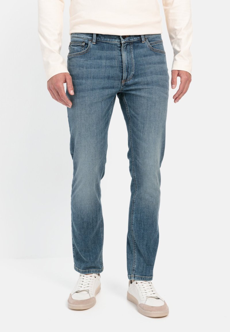 Lichtblauwe denim jeans met een rechte snit, uitgerust met vijf zakken en subtiele vervaging. Geko combined met witte sneakers en een lichtgekleurde langemouwen top.