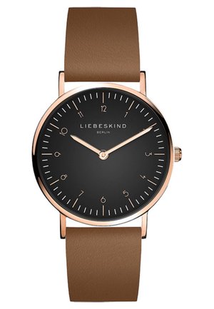 Montre ronde avec un cadran noir, index et aiguilles en or rose. Le bracelet en cuir marron présente une texture lisse. Design minimaliste.