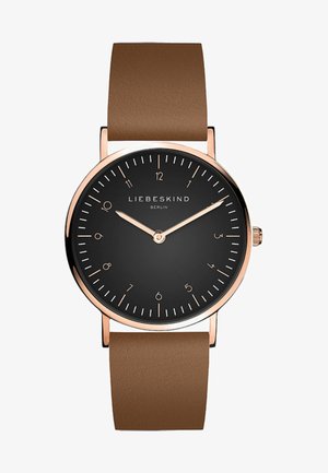 Rund ur med en sort skive, roseguld timeindikatorer og -viser. Brun læderrem med en glat tekstur. Minimalistisk design.