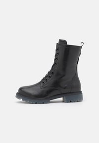 Bota negra de cuero hasta el tobillo con múltiples ojales, parte frontal con cordones, cuello acolchado y suela de goma gruesa con un ligero tono azul.