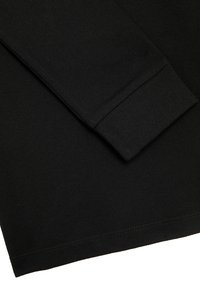 Zwarte textuur lange mouw shirt met een geribbelde manchet en een net gestikte zoom, tentoonstelt een eenvoudig en minimalistisch ontwerp.