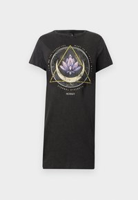 Svart T-shirt med korta ärmar, med en lotusblomma grafik och geometriska former i lila och guld. Tillverkad av bomull, avslappnad passform.