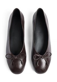 Hnedé kožené baleríny s okrúhlym špičkou, tenkým mašľovým akcentom, hladkým textúrou a polstrovaným interiérom. Podrážka navrhnutá pre pohodlie a flexibilitu.