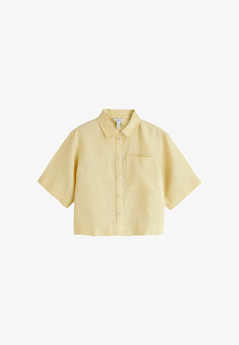 Chemise jaune clair à manches courtes, boutonnée, avec un col et une poche poitrine unique, présentée sur fond blanc.