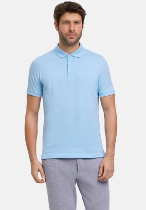 Polo shirt azzurro chiaro a maniche corte con colletto, dotato di tre bottoni e un tessuto liscio e strutturato. Abbinato a pantaloni grigi chiari.