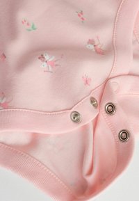 Hele roosa bodi, millel on väikesed lille- ja liblikamustrid. Pehme puuvillane kangas ja alumises osas klõpskinnitused, mis teevad riietamise lihtsaks.