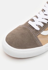 Sneaker in suede e tela con punta rotonda, parte superiore grigia, lacci bianchi e suola in gomma. Presenta cuciture e un accento con logo.