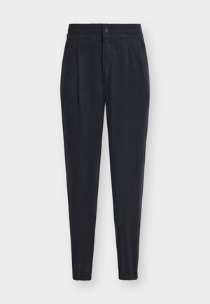 Μαύρο κωνικό παντελόνι με ελαστική μέση, πιέτες μπροστά, κλείσιμο με κουμπί και φερμουάρ και ελαστικά μανσέτα στους αστραγάλους σε λευκό φόντο.