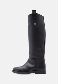 Μαύρη δερμάτινη μπότα μέχρι το γόνατο με λείο φινίρισμα, στρογγυλεμένη μύτη, επίπεδο τακούνι και πίσω ταινία για εύκολη φόρτωση. Απλός και ευέλικτος σχεδιασμός.