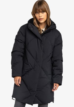Schwarzer, langer Puffer-Mantel mit Rautensteppmuster, Kapuze und leicht übergroßen Ärmeln, mit Reißverschluss und seitlichen Taschen.