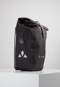 Zaino impermeabile nero con chiusura a roll-top, hardware grigio e dettagli riflettenti del logo di Vaude, caratterizzato da una texture in nylon durevole.