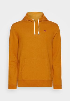 Sweat à capuche jaune moutarde avec cordons blancs, poche kangourou, et petite étiquette de logo rouge sur le côté gauche de la poitrine.