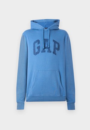 Blå hettegenser med "GAP"-logo på forsiden, med snor i hetta og kengurulomme, vist på hvit bakgrunn.