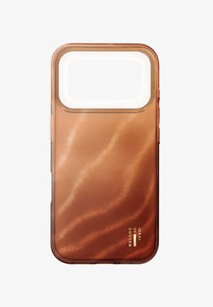 Funda de teléfono translúcida color cobre con un amplio recorte para la cámara y el logotipo de "Ideal of Sweden" en dorado en la esquina inferior derecha.