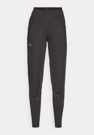 Leggings deportivos negros con una cintura alta, tela suave y bolsillos laterales. El logo de Puma aparece en blanco en el muslo izquierdo.