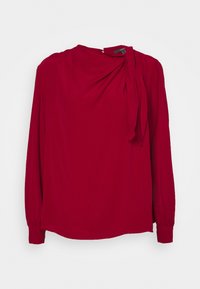 Punainen pitkähihais blouse, jossa on kerätty kaula-aukko ja sivupitsi. Siisti kangas, jossa on hieman roikkuva siluetti ja hihansuun käänteet.