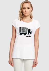 Hvid bomulds t-shirt med et sort grafisk design af en stregkode med en stiliseret dyresilhuet, som skaber en kontrast i tekstur og farve.