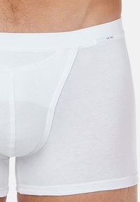 White cotton boxer briefs with a smooth texture, featuring a wide waistband and a contour pouch for support.
