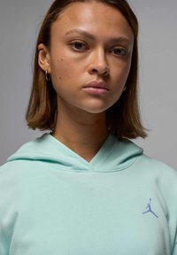 Sudadera de color verde menta con capucha con cordón y logo Jumpman bordado en púrpura en el pecho. Tejido suave con un corte relajado.