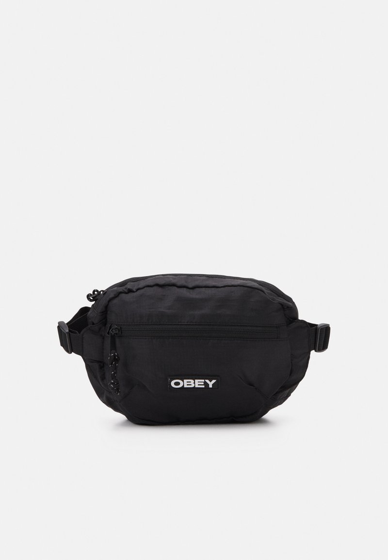 Mala cruzada em nylon preta com um compartimento principal com fecho, bolsa frontal, alça ajustável e um patch branco com o logótipo "OBEY".