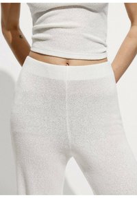 Top in maglia bianca senza maniche e leggings a vita alta, con un motivo testurizzato e una vestibilità aderente, dotati di un design senza cuciture e di un tessuto morbido.