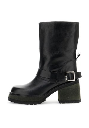 Černá kožená bota do poloviny lýtek s masivním zeleným texturovaným podpateklovým podpatkem, stříbrným zapínáním na pásku a podrážkou s drážkami na bílém pozadí.