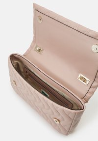 Gequilted roze handtas met een gladde leren afwerking, voorzien van gouden accenten, een ruime binnenkant en meerdere compartimenten voor organisatie.