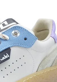 Sneaker in pelle bianca con accenti blu e viola. Presenta perforazioni, una punta testurizzata e una suola in gomma con dettagli marroni.