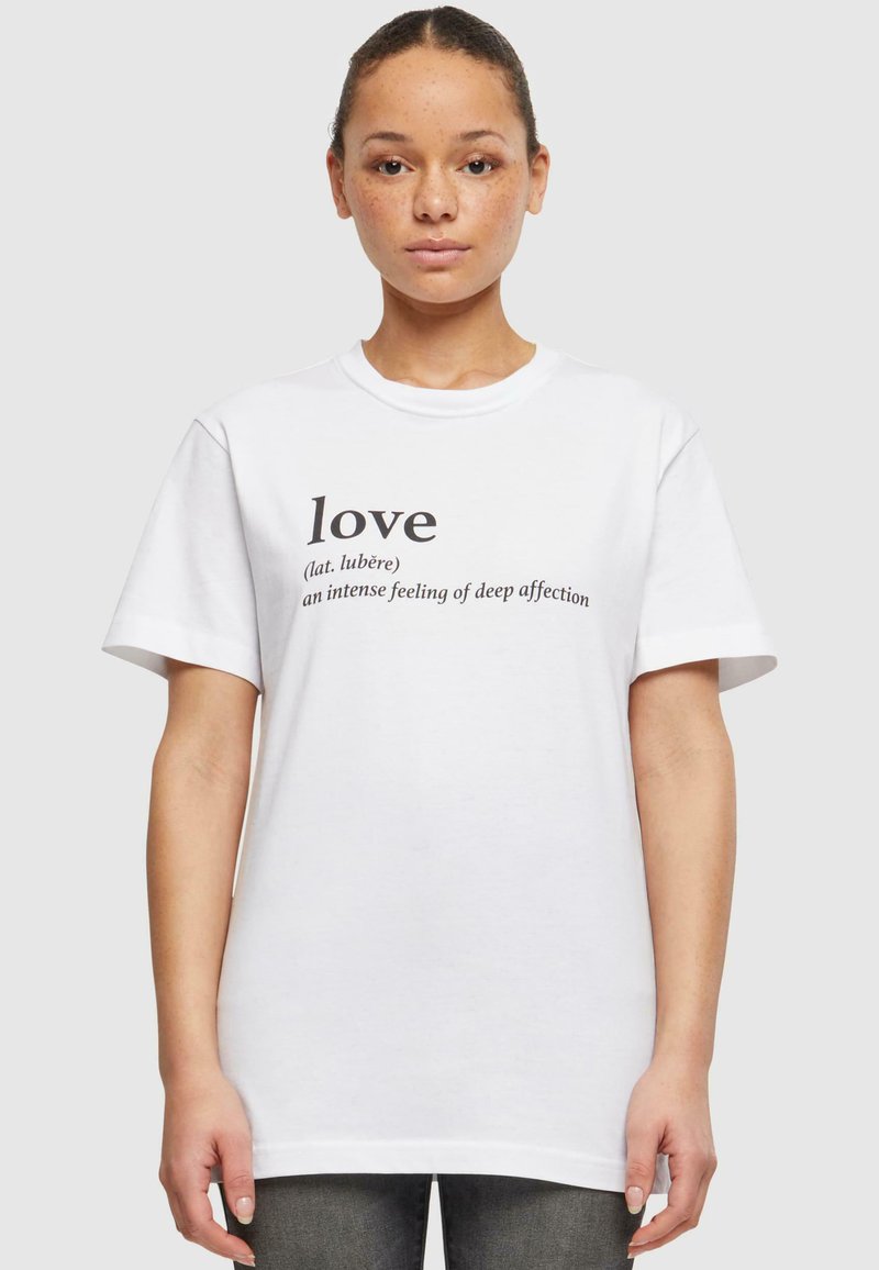 T-shirt en coton blanc avec un graphique en texte noir définissant "amour" et son origine latine, à manches courtes et à coupe décontractée.