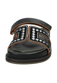Sandal in pelle nera con borchie decorative in argento, dettagli marroni e una larga cintura in pelle. Suola spessa e testurizzata e design con punta aperta.
