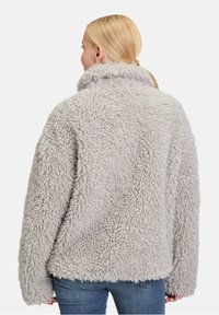 Lichtgrijze fluffy fleece jacket met een hoge kraag en een ontspannen pasvorm, met een gestructureerd oppervlak en verlaagde schouders.