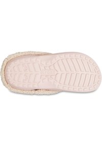 Suela de color rosa claro de una pantufla que cuenta con una parte inferior de goma texturizada para mayor tracción y un exterior suave y esponjoso con un borde color crema.