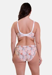 Set bikini con fantasia floreale in tonalità pesca e bianco. Il top presenta spalline regolabili, mentre il pantalone ha un design a vita alta e una cintura elastica.