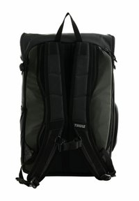Sac à dos matelassé noir et vert foncé avec des sangles réglables, une poignée supérieure et des poches latérales. Présente une texture lisse et un logo de marque.