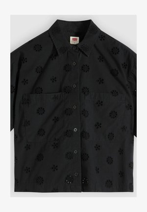 Zwart T-shirt met korte mouwen, voorzien van bloemrijke opengewerkte borduursels, knoopsluiting aan de voorkant, twee borstzakken en een puntige kraag.