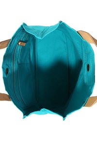 Tygväska med en klar turkos insida, utrustad med en ficka med dragkedja och knappstängning, tillsammans med ljusbruna remmar.