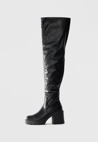 Black over-the-knee boots made of smooth leather, featuring a chunky platform heel and seam detailing along the shaft.