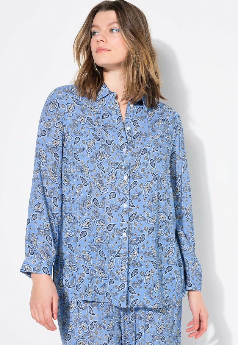 Lichtblauwe overhemd met knopen, versierd met een paisleypatroon in blauw en wit. Lange mouwen met een relaxte pasvorm en een zachte textuur.
