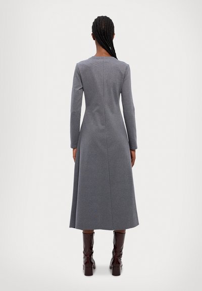 Gray long-sleeved dress with a fitted bodice and flared skirt, featuring a straight neckline and back seam. Paired with knee-high brown boots.