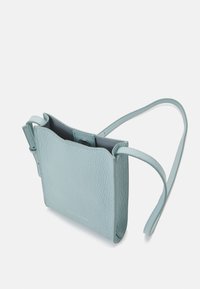 Borsa a tracolla piccola in pelle blu chiaro con texture granellata e chiusura a scatto magnetico su uno sfondo bianco.