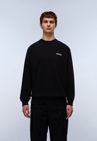 Sort sweatshirt lavet af bomuld, med ribbet halsudskæring og manchetter, samt en lille logo detalje på brystet. Kombineret med sorte cargo-bukser.