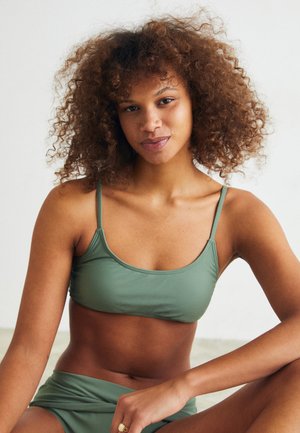 Olivovozelený bikini set, ktorý obsahuje priliehavý braletový vrch s tenkými ramienkami a zodpovedajúce vysoké nohavičky, vyrobené z hladkého, elastického materiálu.