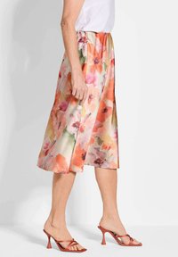 Blumiger Midi-Rock aus weichem, leichtem Stoff in Pastellfarben wie Pfirsich und Pink, mit einem fließenden Design und elastischem Bund.