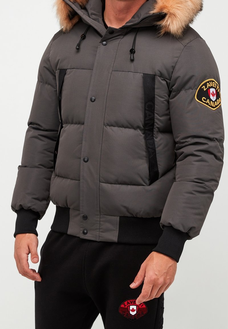 Gray puffer jacket with a fur-trimmed hood, front snap closures, black accent panels, and a Canada logo patch on the sleeve.
