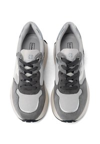 Sneaker sportive in una combinazione di colori grigio e argento. Presentano materiali in mesh e suede, linguetta imbottita e lacci. Suola spessa con dettagli testurizzati.