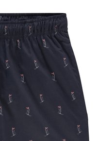 Marineblå shorts i stoff med elastisk midjebånd, prydet med et gjentatt motiv av en skiløper i hvit og rød broderi på en glatt tekstur.