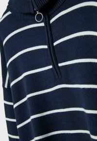 Marineblauer Pullover mit weißen horizontalen Streifen, hohem Kragen und Reißverschluss mit rundem Zipper. Weiche Textur und lockere Passform.