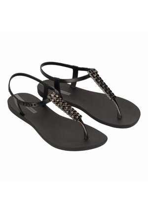 Chanclas negras con suela texturizada y acentos de tira trenzada metálica. Diseño tipo thong con tirantes traseros ajustables para un mejor ajuste.
